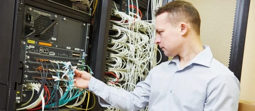 Network Support Technician checking server hardware equipment of data center.