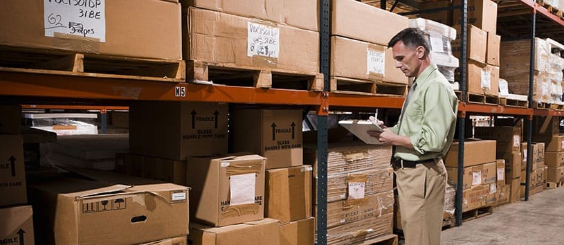 Supply Chain Management professional counting inventory in a warehouse.
